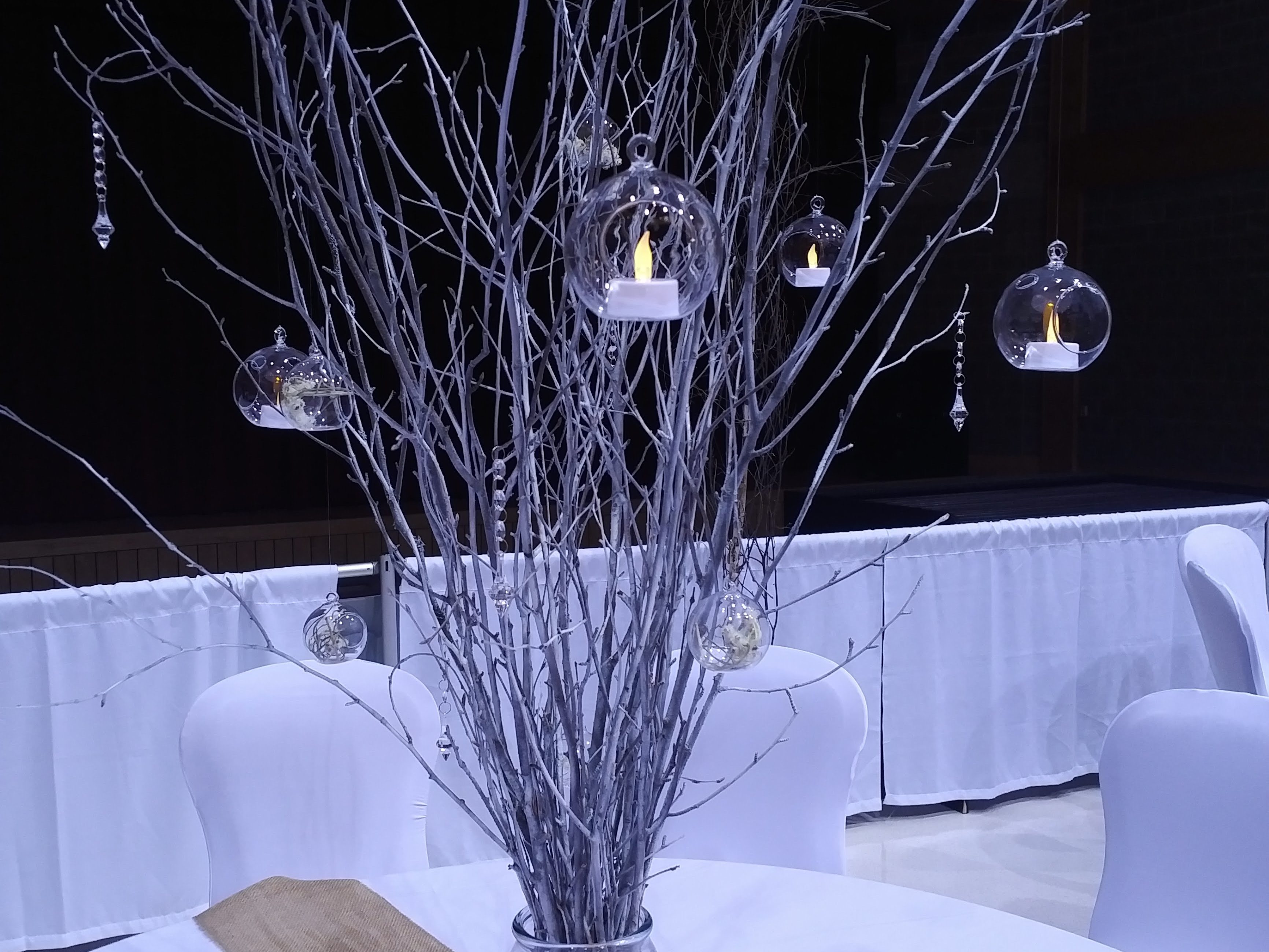 Tree branch centerpiece with hanging jewels.